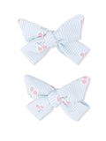 Light blue striped hair bows with pink cherry patterns, arranged in a pair.