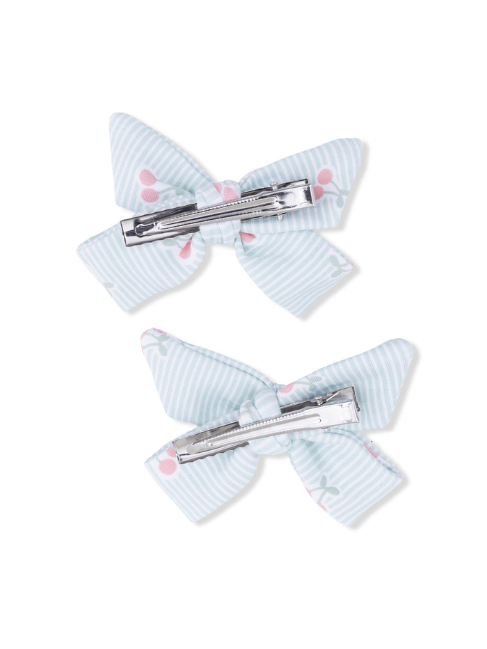 Two pastel blue hair bows with floral patterns and metal clips, arranged side by side on a white background.