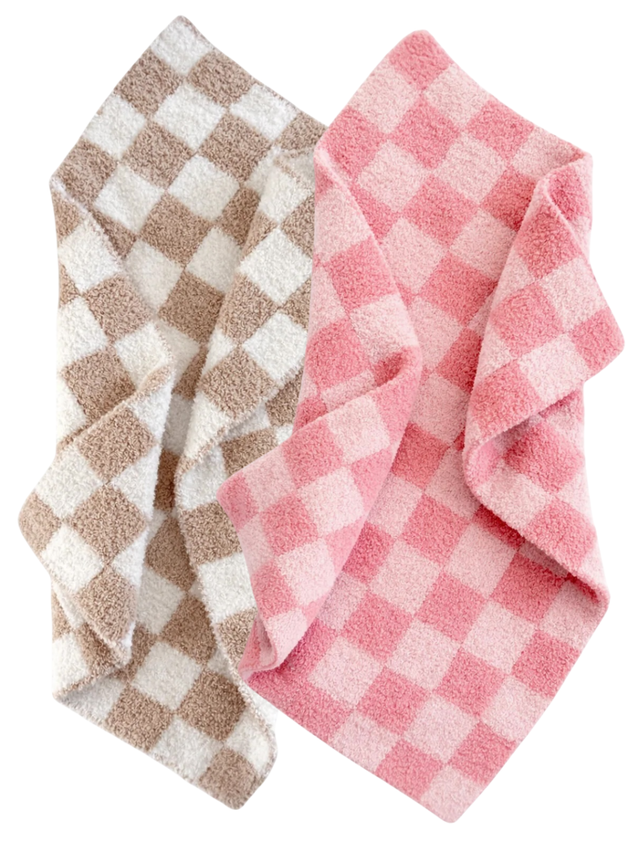 Two soft, checkered blankets in pink and beige tones, folded together.