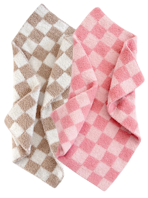 Two soft, checkered blankets in pink and beige tones, folded together.