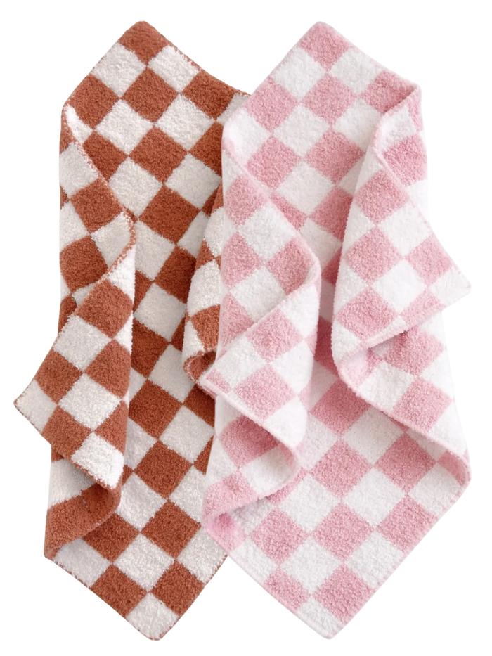 Two checkered towels, one in brown and white, the other in pink and white, folded and layered together.