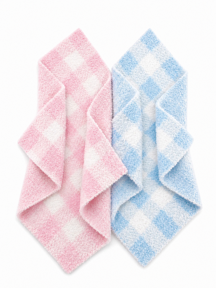 Pink and blue checkered washcloths stacked in a diagonal arrangement against a white background.