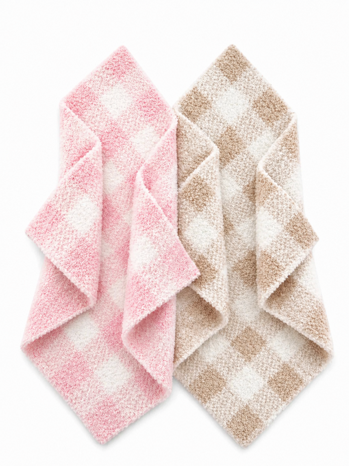 Two folded checkered towels in pink and brown colors on a white background.