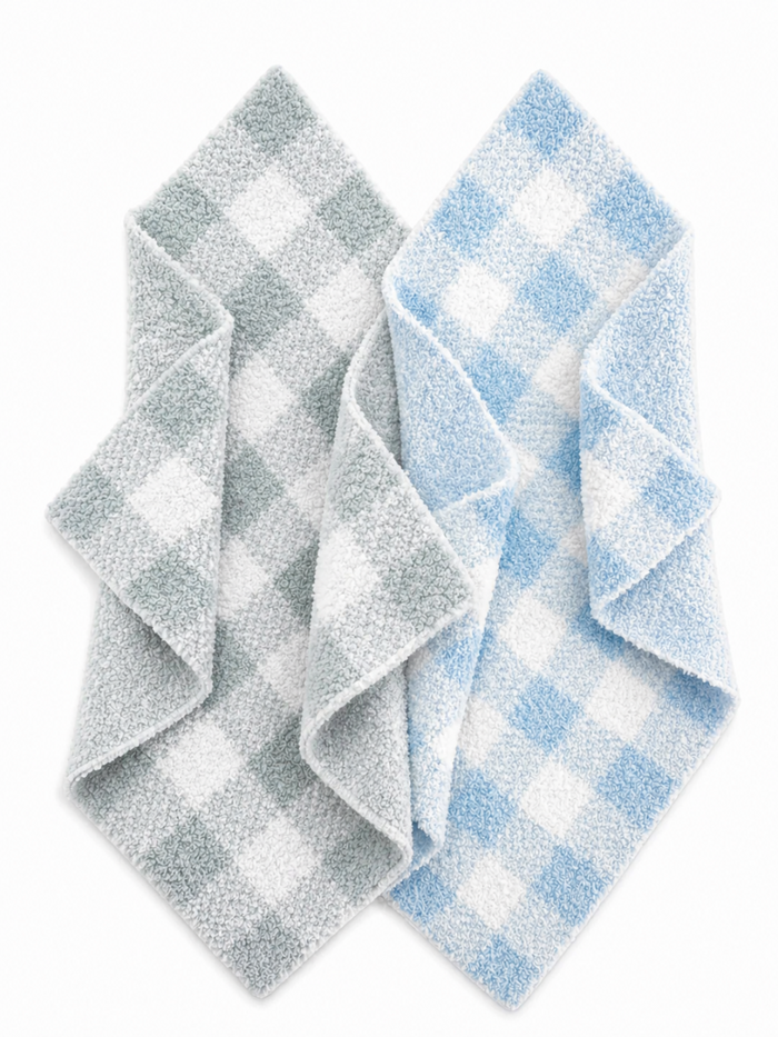 Two checkered towels, one in gray and white, the other in light blue and white, neatly folded.