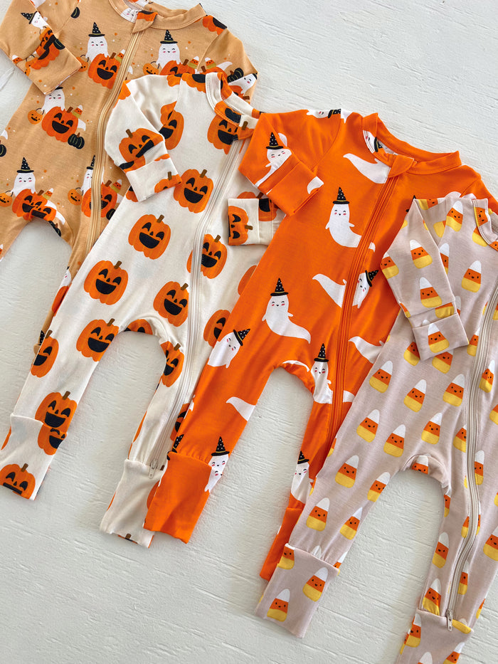 Colorful Halloween-themed baby pajamas featuring pumpkins, ghosts, and candy corn patterns.