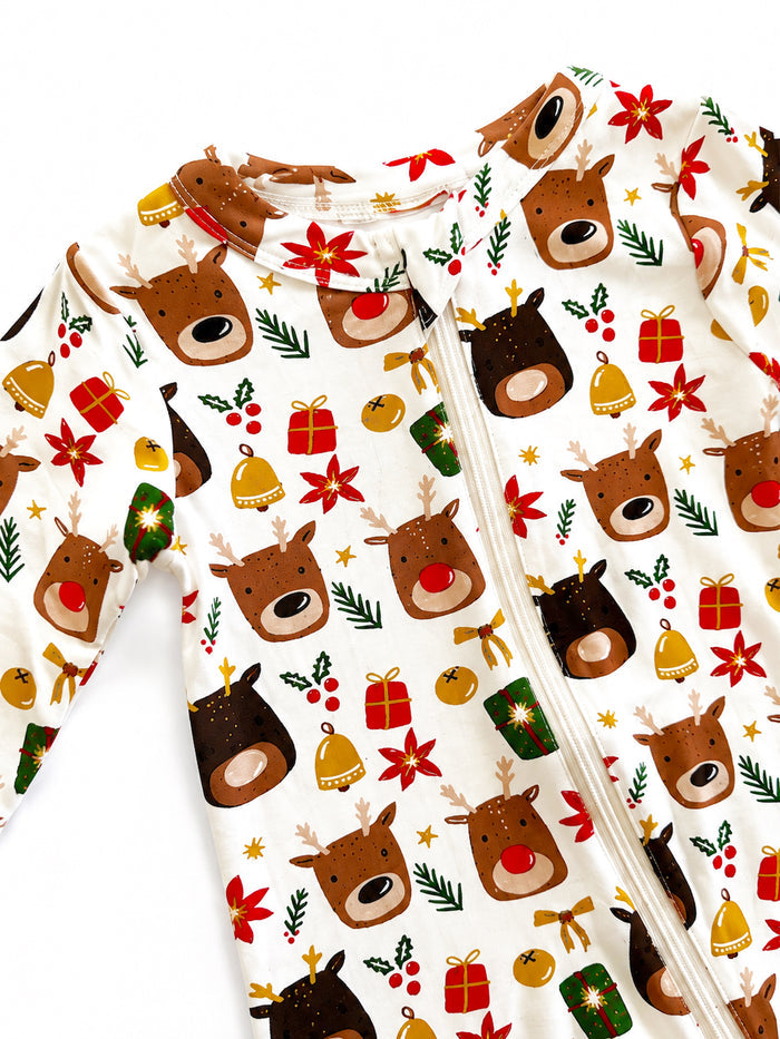 Holiday-themed onesie with reindeer, gifts, and festive decorations on a white background.