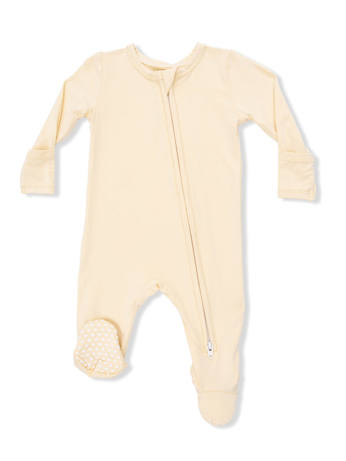 Light yellow baby onesie with a front zipper and polka dot footie detail.