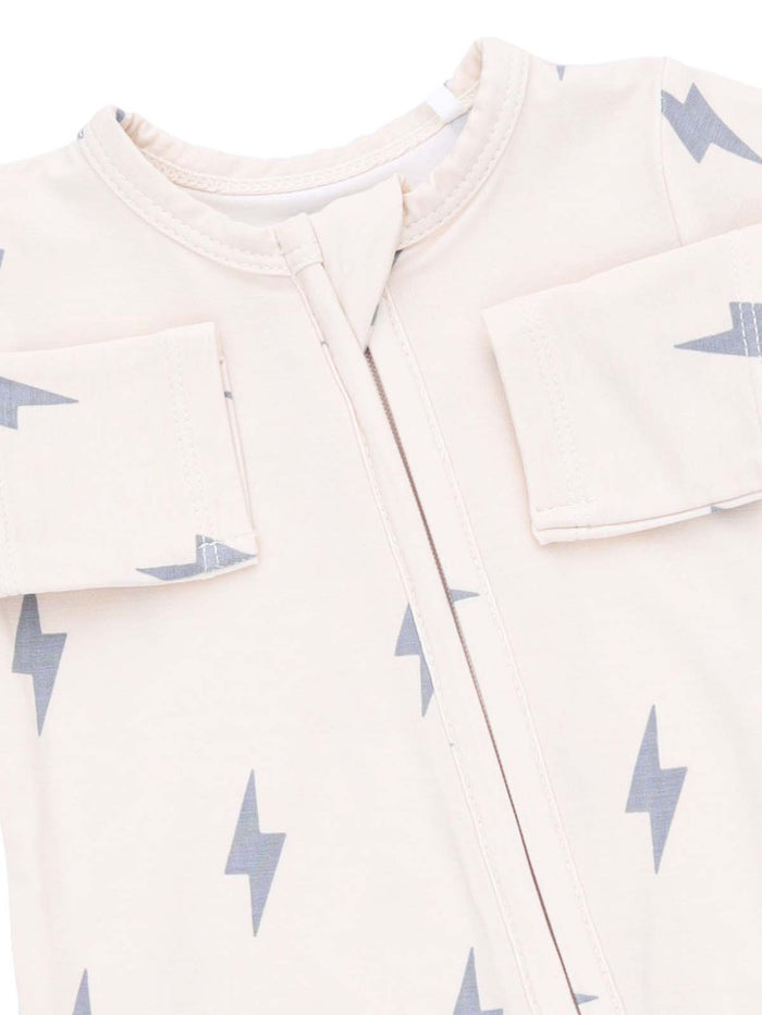 Light-colored baby outfit with gray lightning bolt patterns and a zip front. Designed for comfort and style.