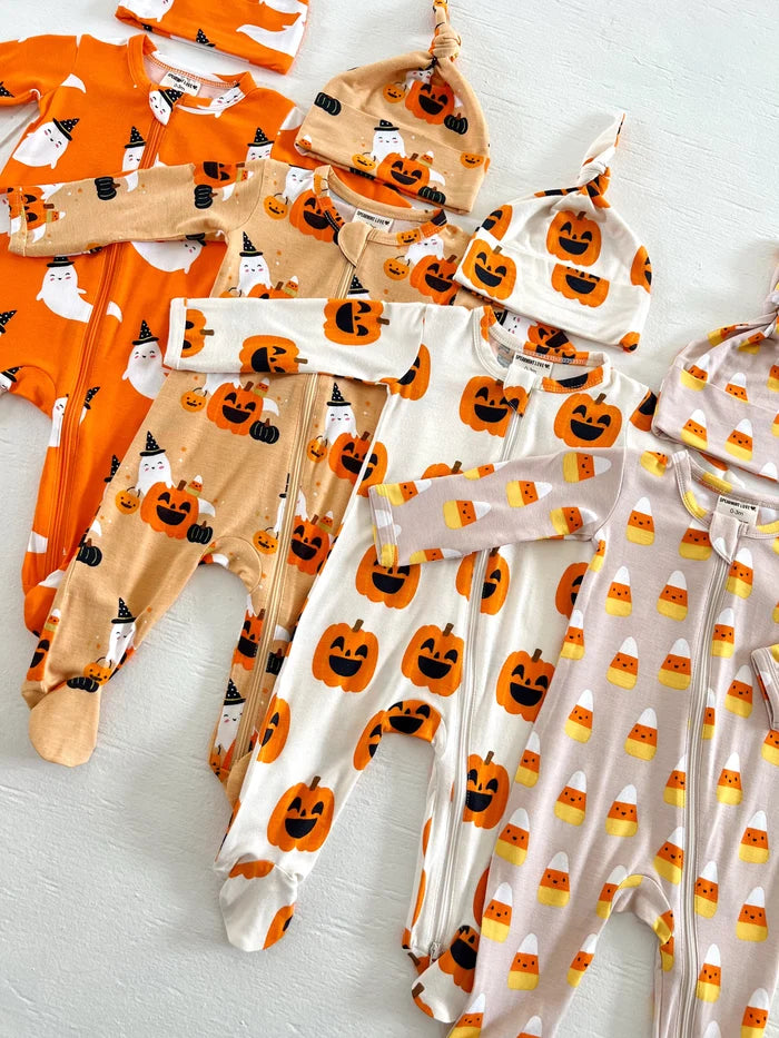Assorted Halloween-themed baby outfits and hats in pumpkin and ghost designs arranged neatly on a white surface.