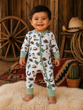 Smiling toddler in a playful, patterned onesie standing on a fluffy rug with rustic decor in the background.