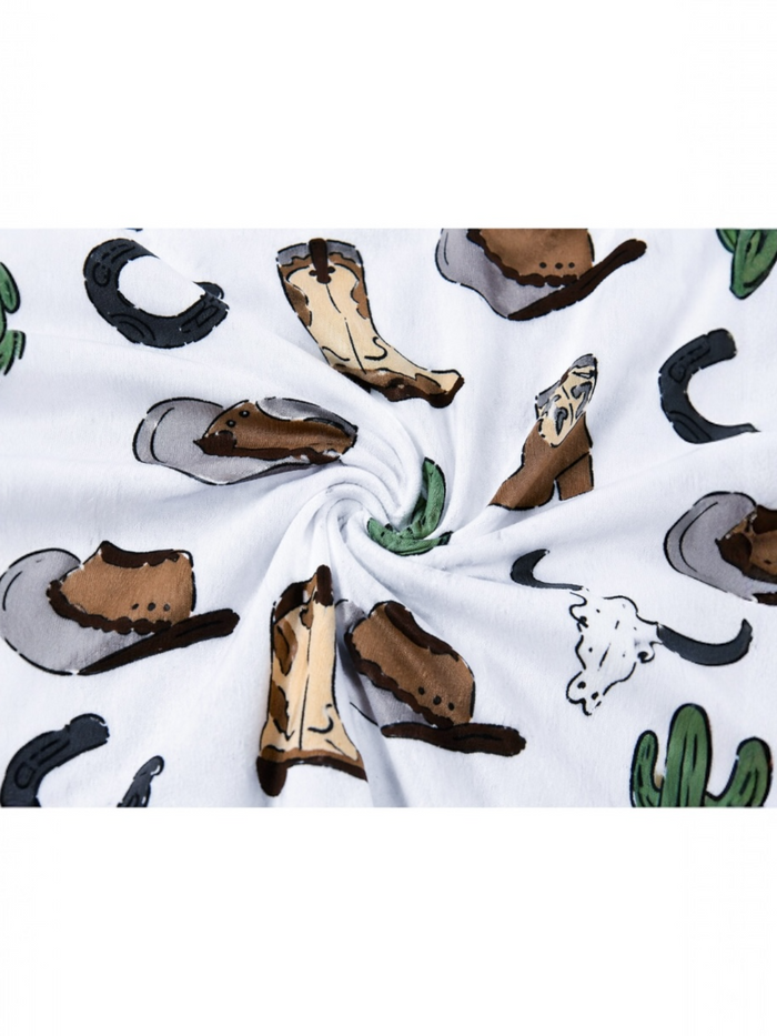 White fabric with a spiral pattern featuring cowboy hats, boots, cacti, and other western-themed icons.
