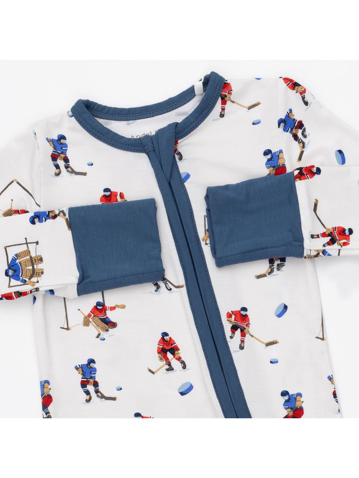 Hockey-themed pajamas featuring figures playing ice hockey on a light background with blue accents.