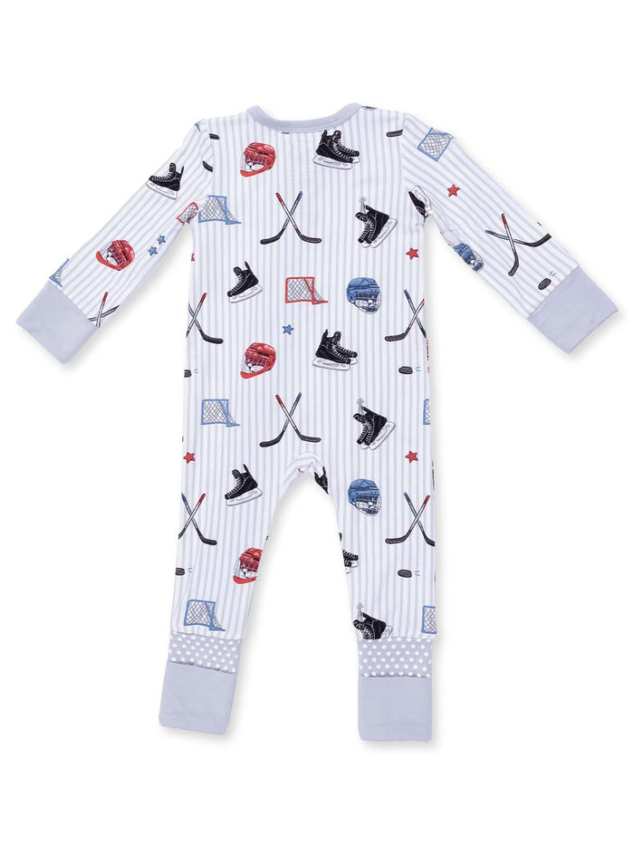 Baby pajama set in light colors featuring hockey gear illustrations, including skates, helmets, and sticks.