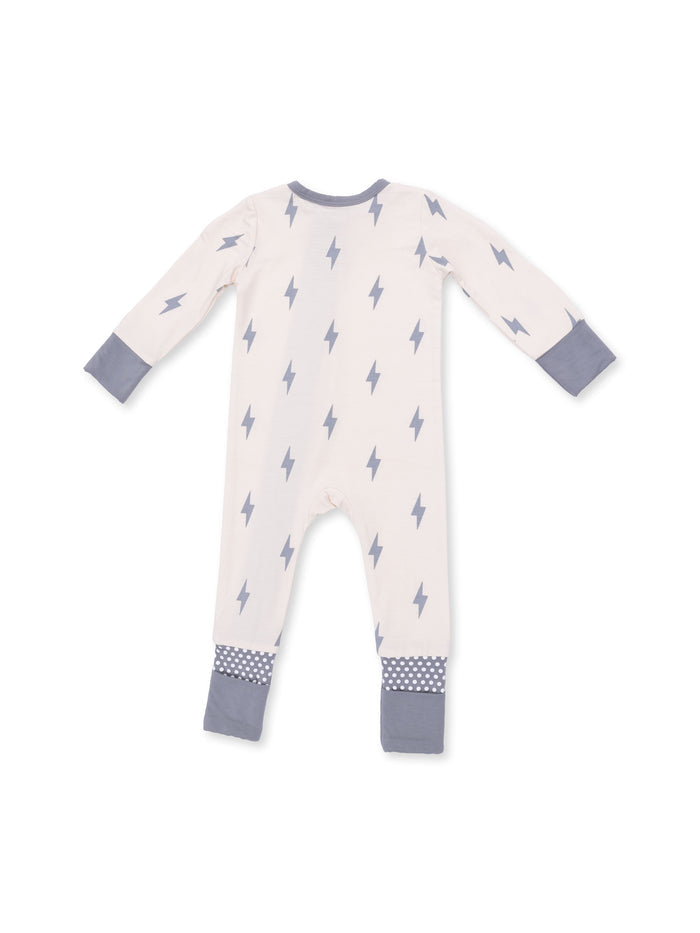 Cream-colored baby onesie with gray lightning bolt pattern and polka dot cuffs on a white background.
