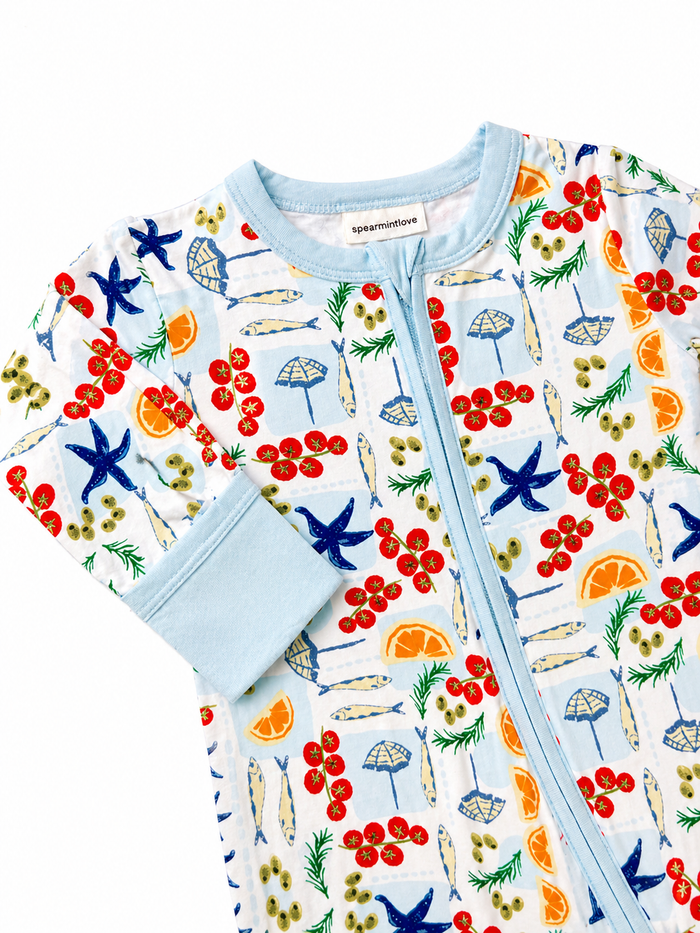 Colorful kids' pajama featuring fruits, sea themes, and playful designs with a light blue trim.