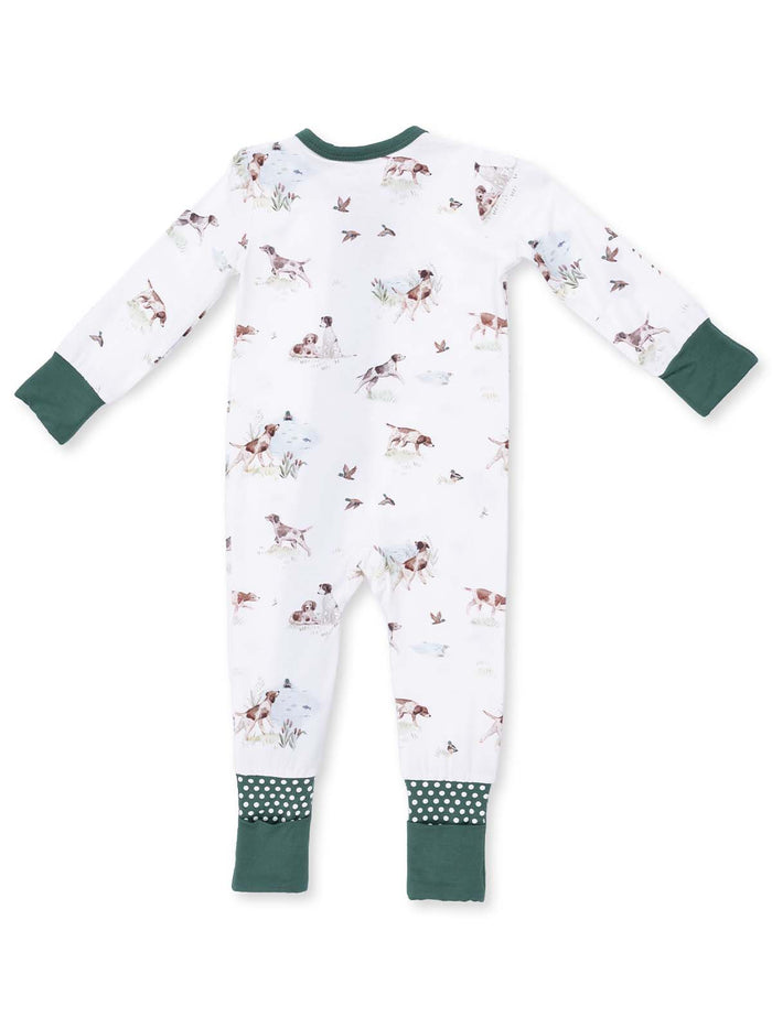 Back view of a baby onesie featuring a playful dog and bird pattern with green trim and polka dot accents.