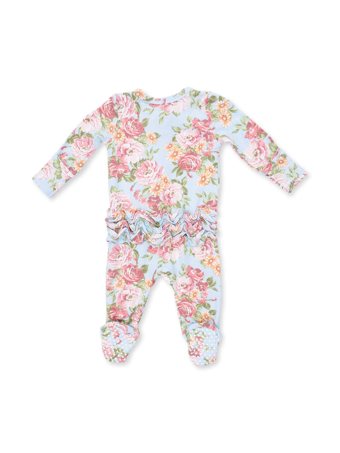 Floral-patterned baby onesie with ruffles and footed design in light blue background.
