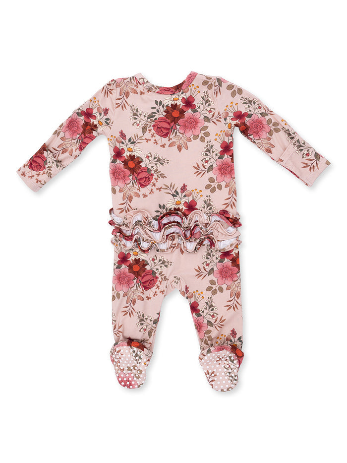 Floral infant onesie with ruffled waist and polka dot grip feet, ideal for comfort and style.
