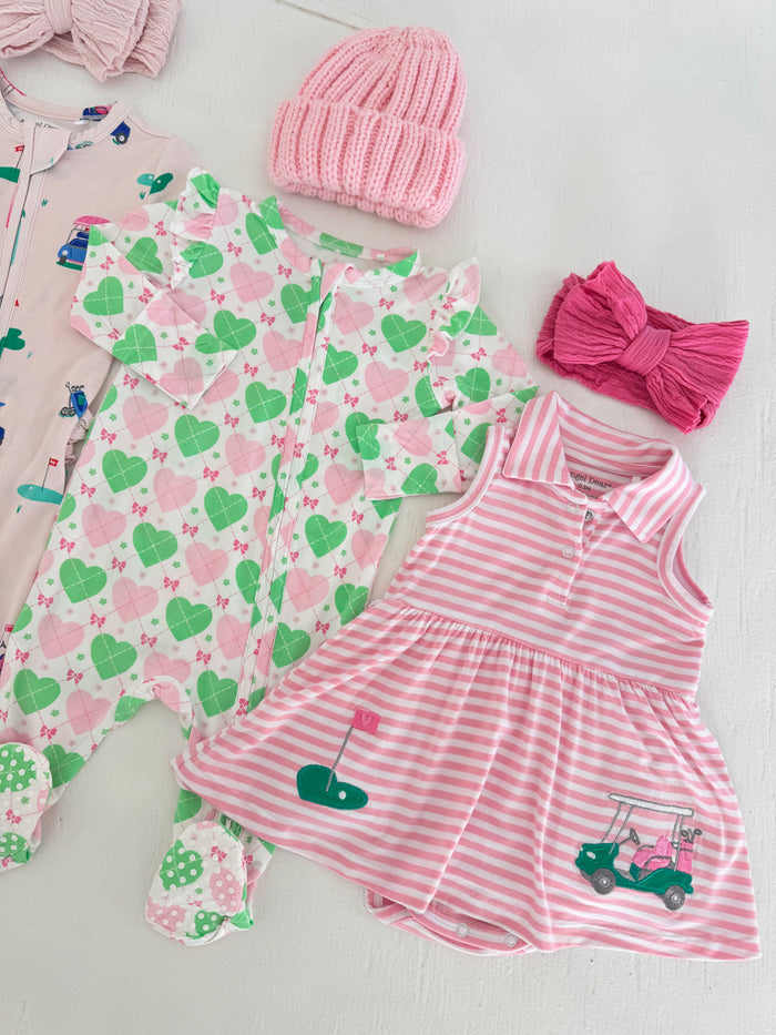 Infant clothes collection: a pink striped dress, heart-patterned onesie, pink beanie, and hair bow on a white background.