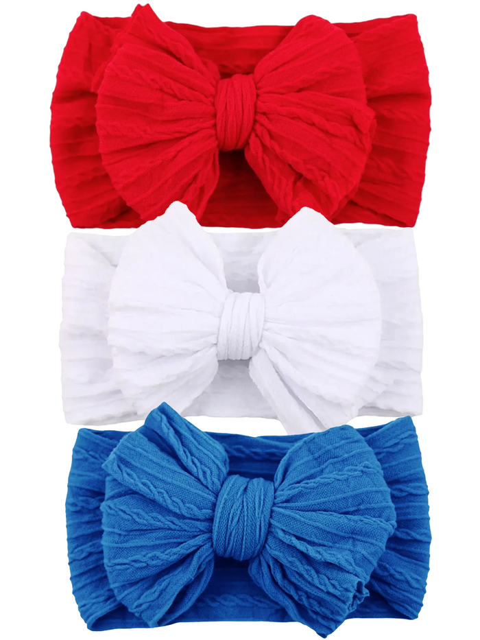 Three headbands in red, white, and blue, each featuring a large textured bow. Perfect for festive occasions.