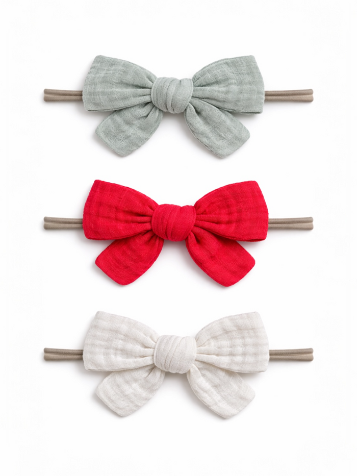 Three fabric hair bows in gray, red, and white on elastic bands, arranged vertically against a white background.