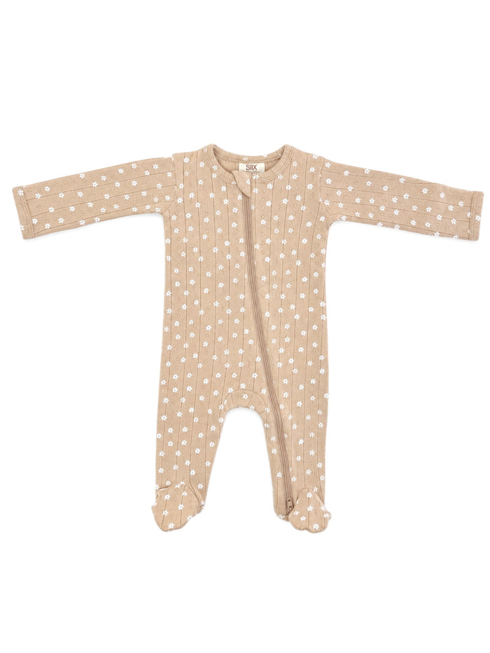 Tan baby onesie with white floral pattern, featuring long sleeves and a front zipper closure.