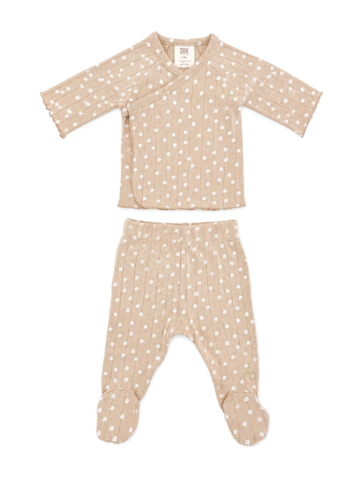 Beige baby outfit with white floral pattern, featuring a wrap top and footed pants. Ideal for infants.