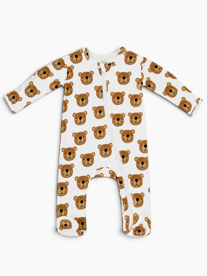 White baby onesie with bear face pattern, featuring long sleeves and a front zip closure.