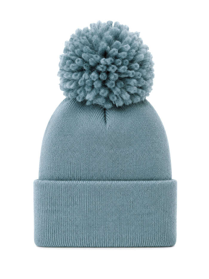 Light blue knit beanie with a large pom-pom on top, perfect for winter wear and casual style.
