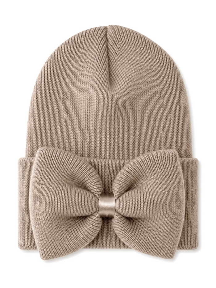 Beige knit beanie with a large bow detail on the front, suitable for stylish winter wear.