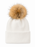 White beanie hat with a large tan fur pom-pom on top, featuring a cuffed design.