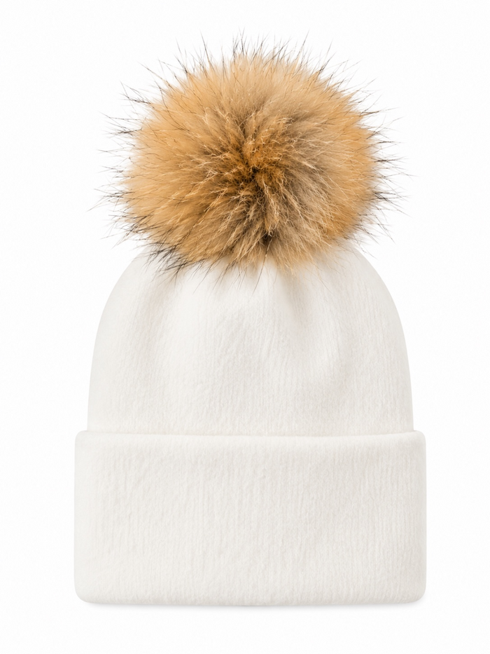 White beanie hat with a large tan fur pom-pom on top, featuring a cuffed design.