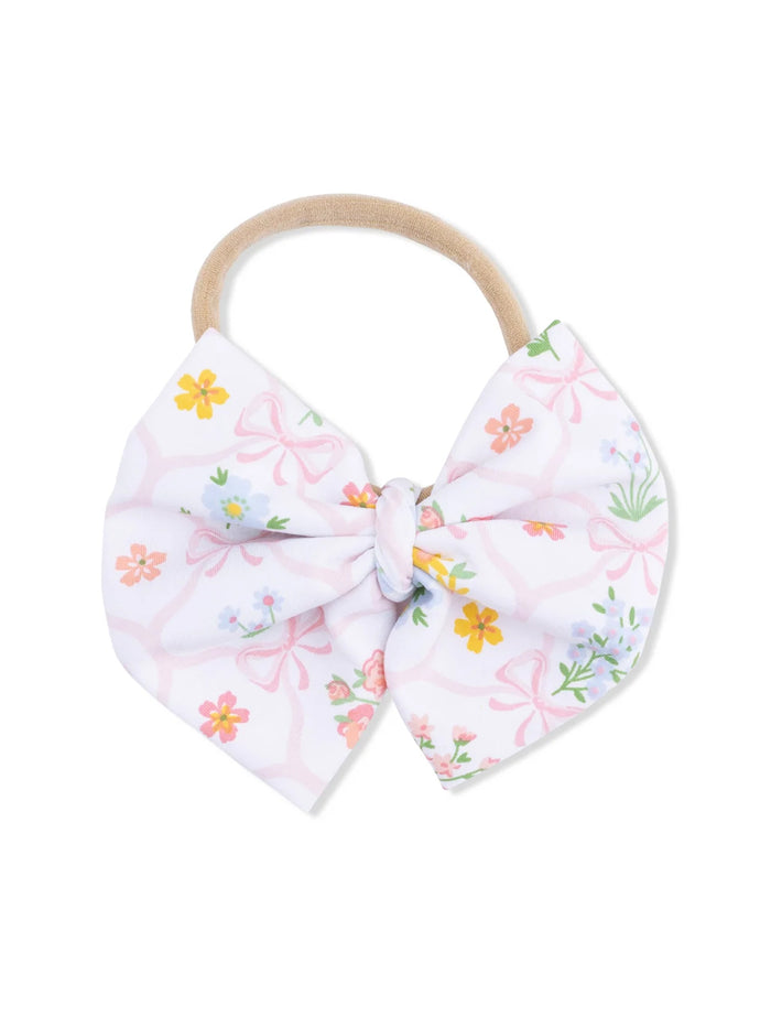 Floral patterned hair bow with a beige elastic band for hair accessories.