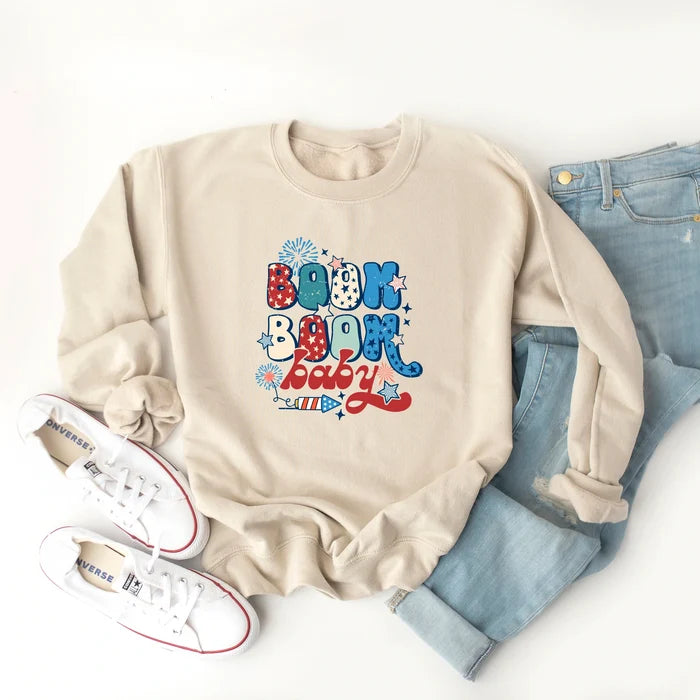 Beige sweatshirt with "Boom Boom Baby" design, paired with light jeans and white sneakers. Ideal for casual wear.
