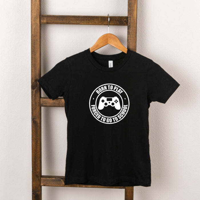 Black t-shirt with white graphic saying "Born to Play, Forced to Go to School" and a gaming controller design.