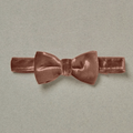 Rose velvet bow tie on a light gray background, showcasing its soft texture and elegant design.