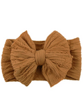 Brown textured headband with a large bow, perfect for adding style to any outfit.