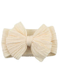 Cream-colored hairband featuring a large, textured bow design. Perfect for adding a stylish touch to any outfit.
