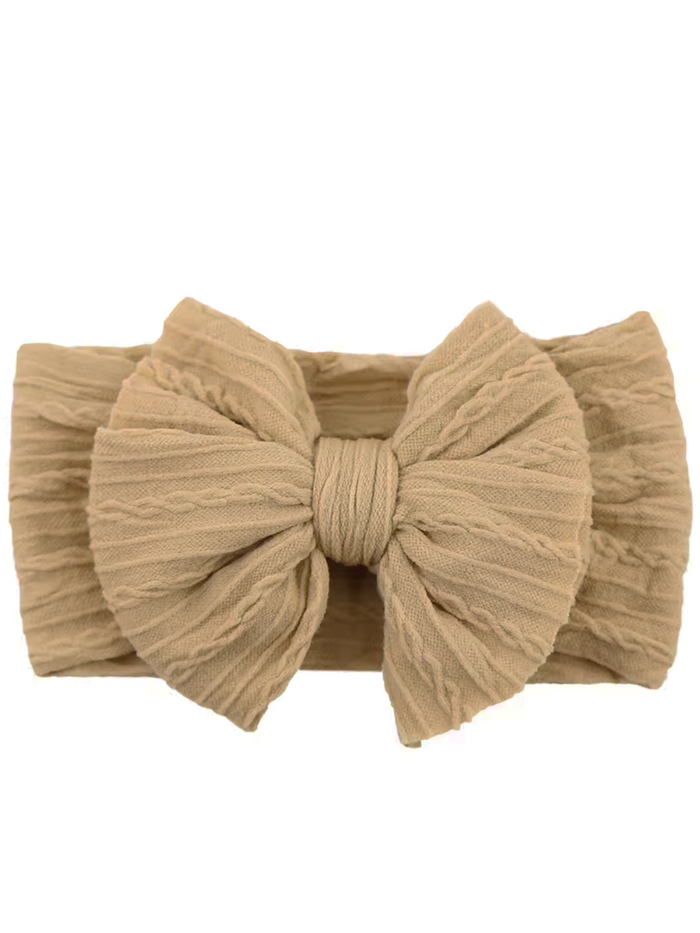 Light beige fabric headband with a large textured bow in the center. Perfect for stylish hairdos.