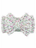 Floral-patterned hair bow in soft white fabric with pink and green accents. Perfect for adding a cute touch to hairstyles.