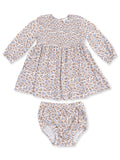 Floral smocked baby dress with long sleeves and matching bloomers in soft white, blue, and brown colors.