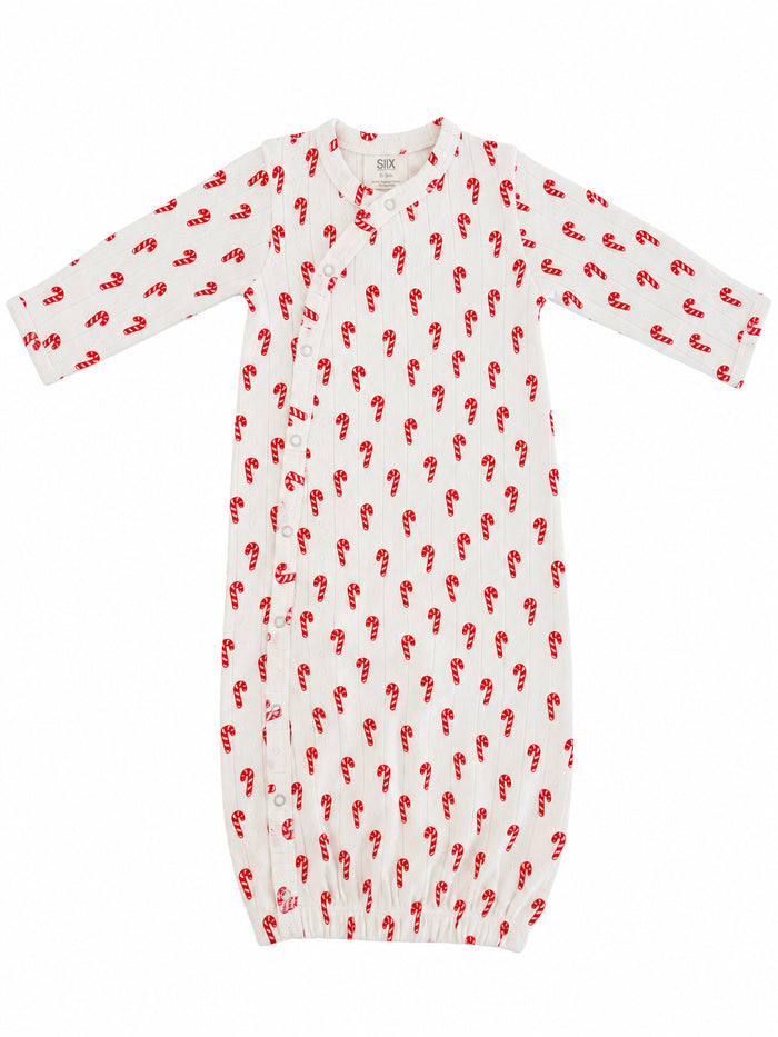 White baby gown with red candy cane print and snap buttons, ideal for seasonal wear.