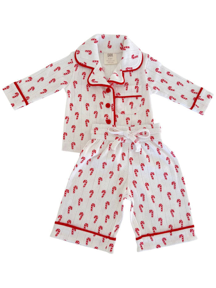 White pajama set with red candy cane design, featuring a collar and contrasting trim.