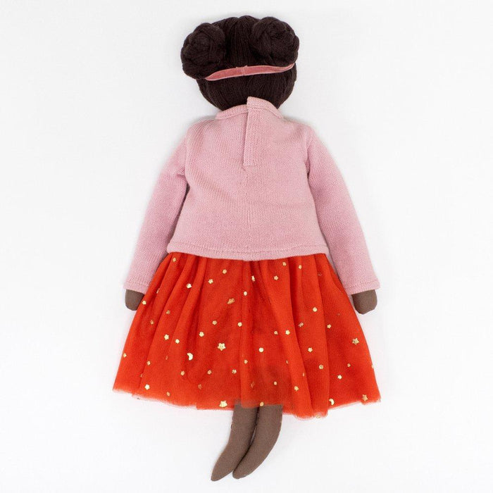 Soft doll with brown skin, wearing a pink top and an orange tulle skirt adorned with gold stars.