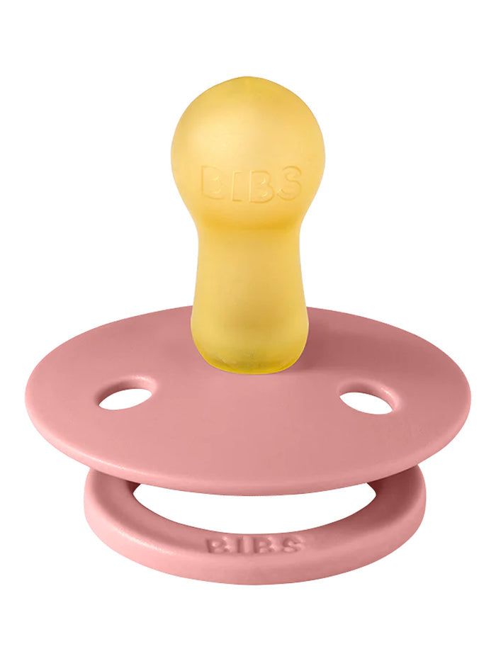 Pink pacifier with a yellow nipple, featuring the brand name "BIBS" embossed on both parts.