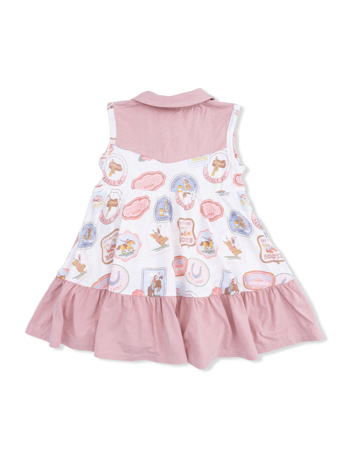 White dress with pink accents, featuring rodeo-themed patterns and a ruffled skirt.