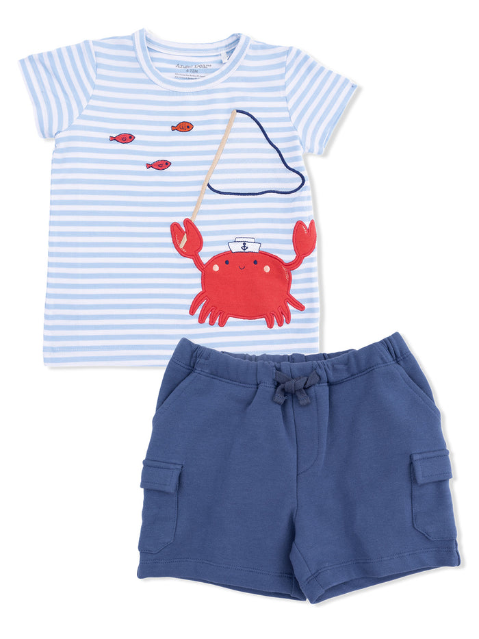 Blue striped shirt with a crab graphic and navy shorts laid out together.