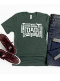 Green t-shirt with "DAD" and descriptive words laid out with jeans and burgundy sneakers.