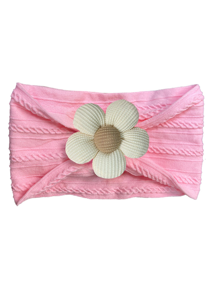 Pink headband with textured fabric and a large white flower embellishment at the center.