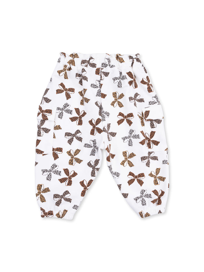 White pants with a colorful bow pattern in brown and black hues, featuring an elastic waist and cuffs.